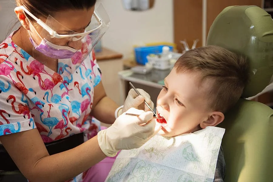 pediatric dentist cleaning child’s teeth